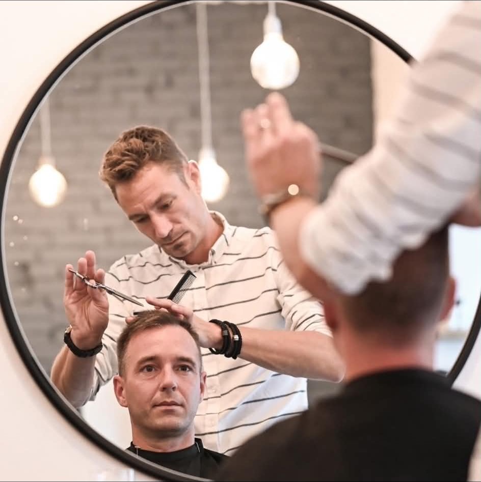 Mikkel Emil arbejder med klip foran spejlet hos CutsByME